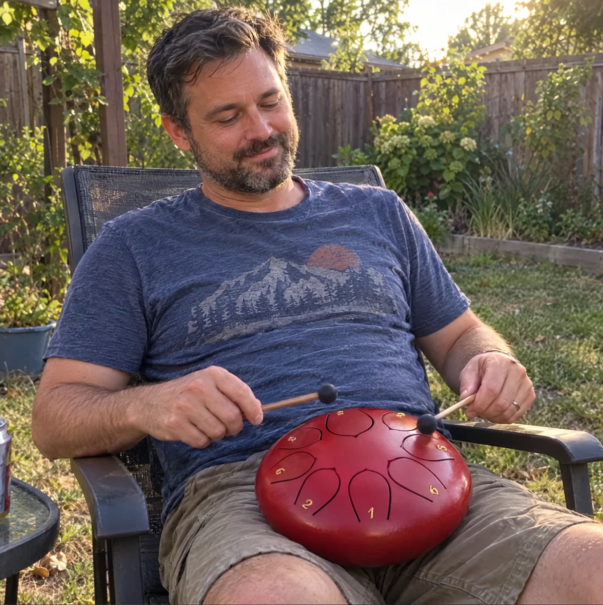 A man in his garden playing a red Calm Drum on his lap