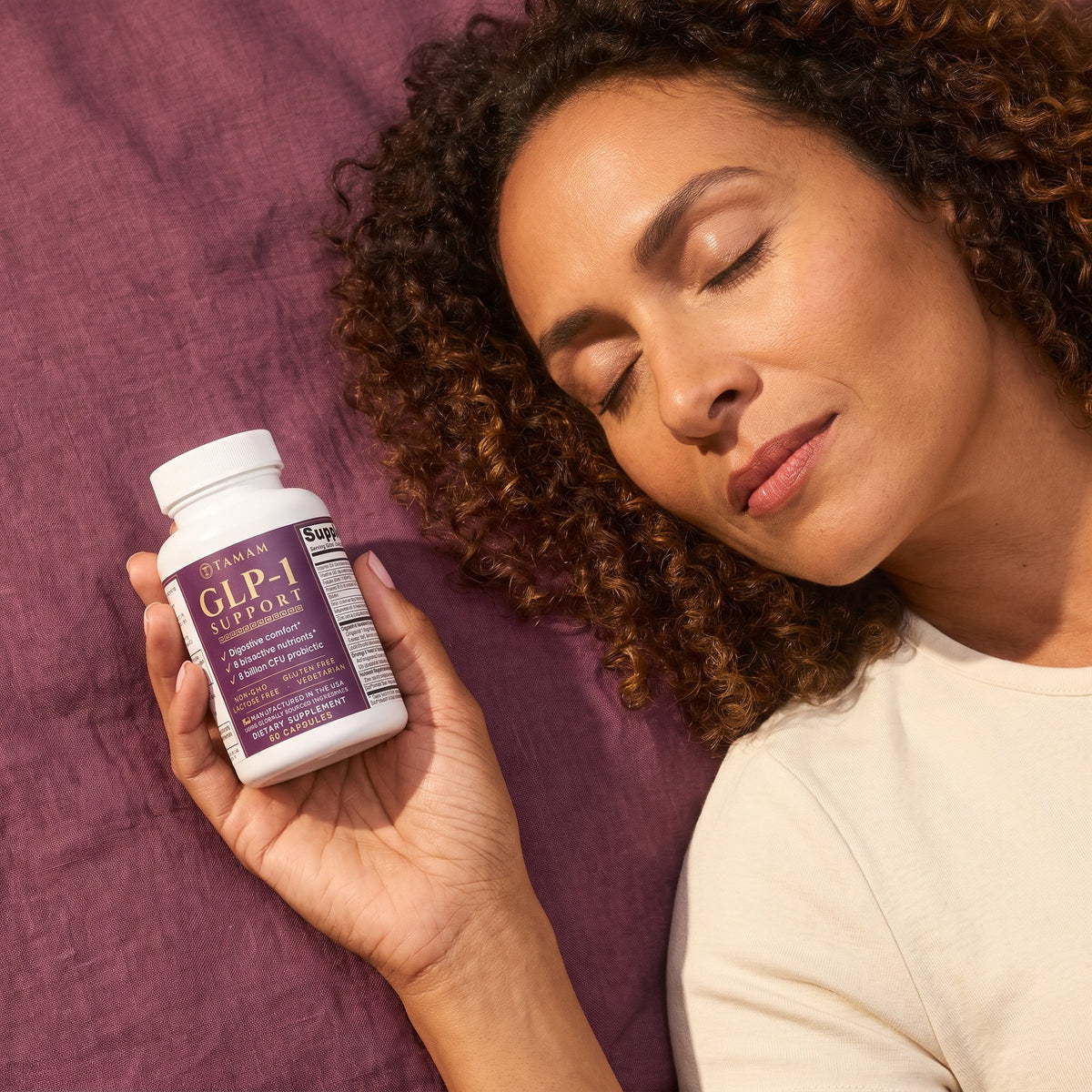 Woman resting on plum linen with TAMAM